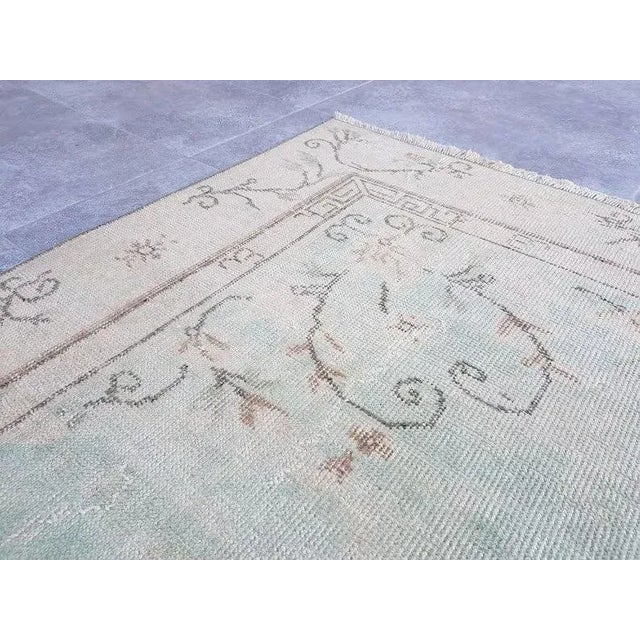 This is a vintage Turkish Oushak rug from the 1960s. The piece was hand-knotted.