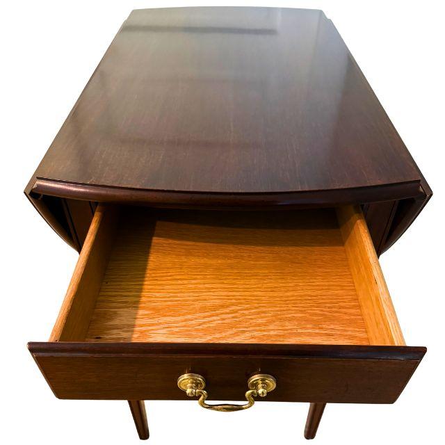 A beautiful and functional rectangular Hepplewhite-style mahogany Pembroke folding table with a single, dovetailed drawer...