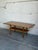 This Danish oak coffee table pairs a long rectangular form with a patterned ceramic tile top. A lower slatted shelf spans...