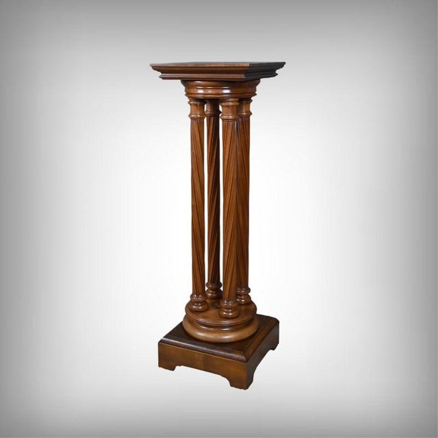 Elegant and unique, this walnut pedestal table is distinguished by its rotating top, resting on four twisted columns....
