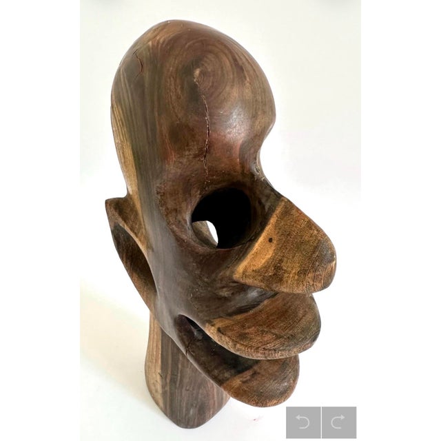 This striking handcrafted abstract wooden head sculpture dates from the 1960s–70s and is carved from richly grained...