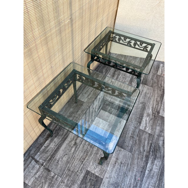 A pair of Late 20th Century Wrought Iron Glass Top Side Tables. Features cast iron frames with cabriole legs, a frieze...