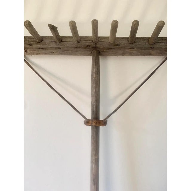 An antique early 20th century French country style hand-made wooden hay rake. This piece would be the perfect sculptural...