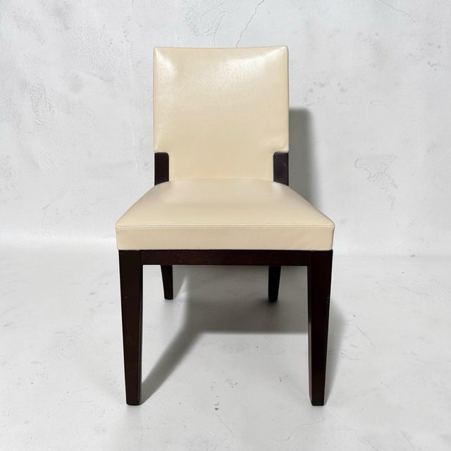 A pair of side dining chairs from sought-after designer Holly Hunt. Handmade with a solid walnut frame, a veneered back...
