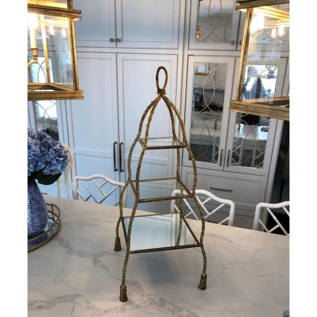 Three tier serving stand featuring mirrored glass shelves and gold colored metal rope details. Classic, timeless design to...