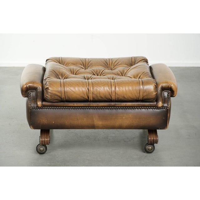This unique and elegant English Chesterfield ottoman, made of cowhide leather, stands on casters and is finished with...