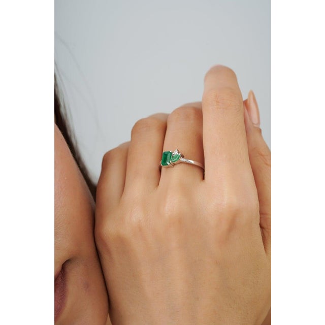 Crafted in 925 sterling silver, this elegant cluster ring features octagon and marquise-cut emeralds totaling 0.77 carats,...