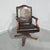 Fine quality brown leather and mahogany swivel office desk chair, standing on brass castors, brass studded and in...