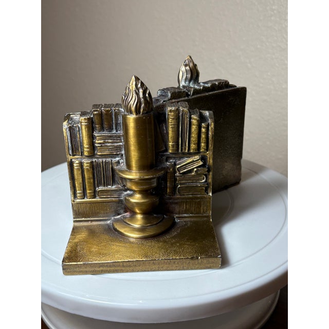 These vintage figural bookends are elaborately cast with intricate detailing depicting large lit candle set in front of a...