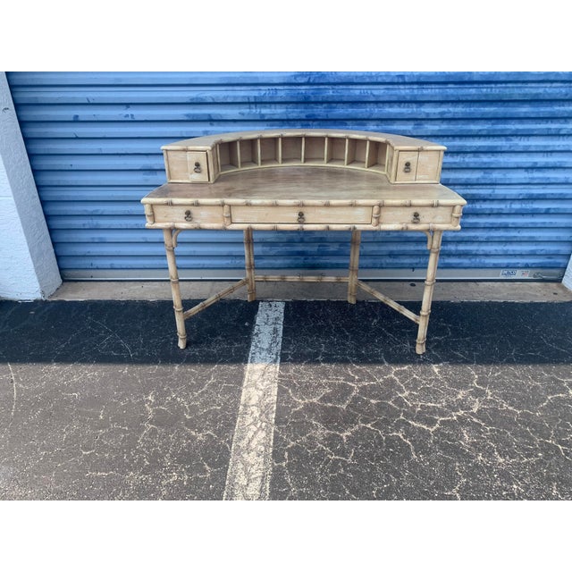 A faux bamboo desk from the mid 20th century made by Ficks Reed. This desk features a semicircular shelf with multiple...