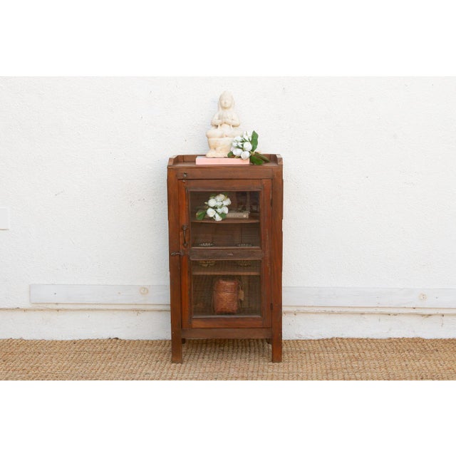 This antique 39-inch tall accent piece is a unique variation of the colonial utility cabinet, featuring glass panes on...