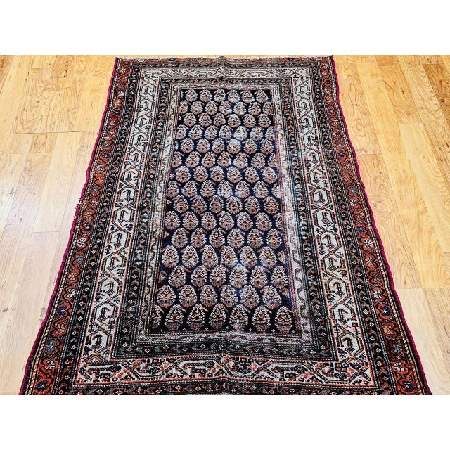 "This elegant early 20th century Persian Malayer area rug features a striking allover paisley motif, a design prized for...