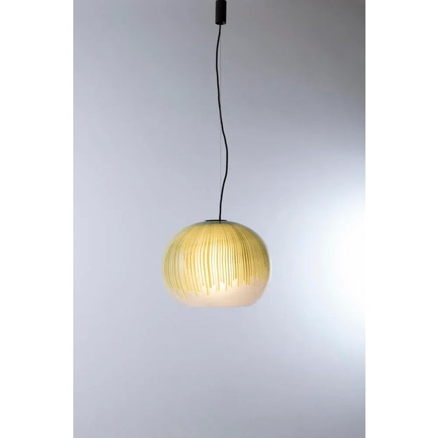 Pendant lamp from the Anemone series with spherical diffuser in transparent glass with green canes and metal structure....