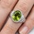 Striking and vibrant, this elegant ring features a luminous green gemstone set in a sleek, sculpted silver band—designed...