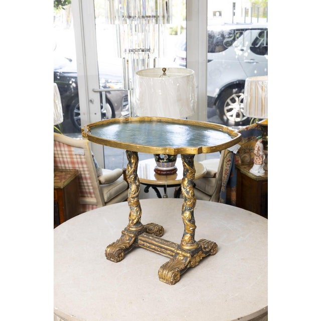 This is an elegant Italian Baroque-style low table featuring a shaped rectangular top with a molded gilt border...