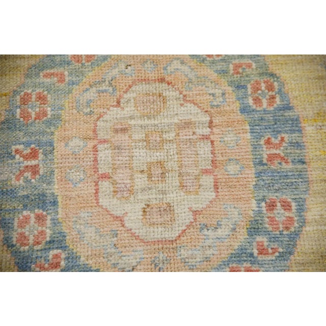 This modern Turkish Oushak rug made from reclaimed vintage wool is a stunning piece of art that has been handwoven using...