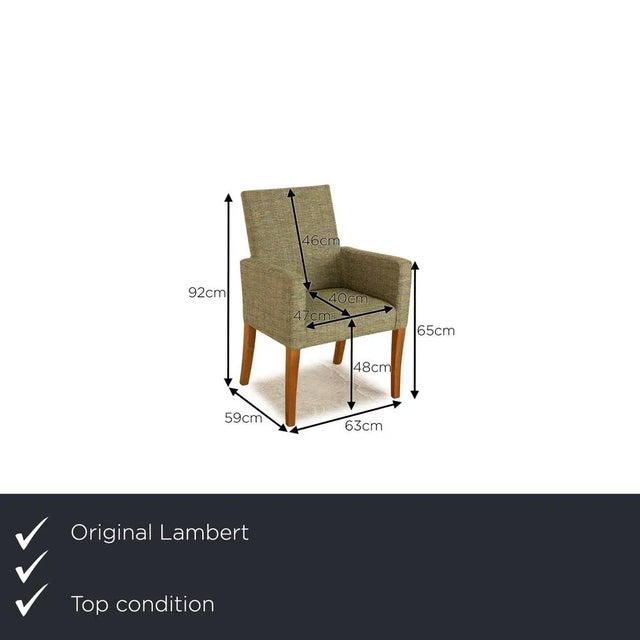 Lambert's Andrew chair is covered with a green fabric and stands on brown wooden feet. It is characterized by the classic...
