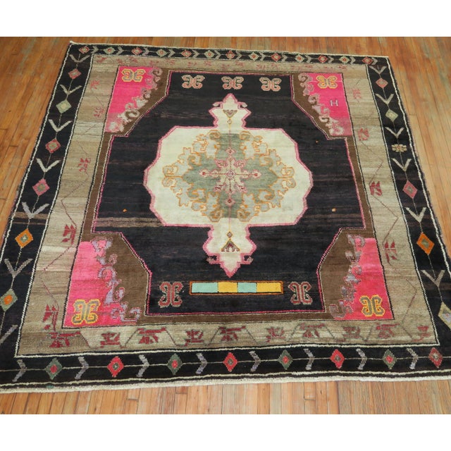 MId 20th Century Turkish Kars Rug with Bright Pink corner accents on a abrashed dark brown ground. The outer border jas...