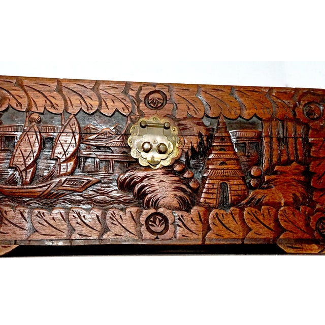 A "remarkable" hand carved mahogany humidor box according to the appraiser has detailed carving of junk boats and temples,...