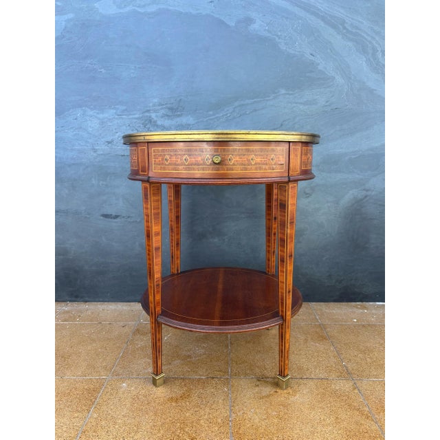 Elegant French side table in the Louis XVI style, dating from the early 20th century. The table features a circular top...