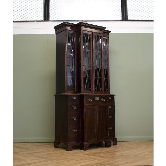A tall, narrow Georgian mahogany breakfront bookcase, offering generous storage within a relatively slim footprint. It...
