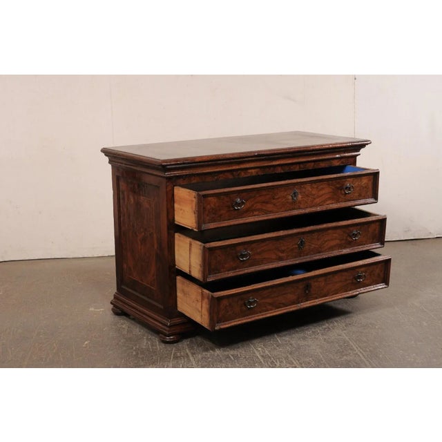 An Italian burl wood veneered chest of drawers from the 18th century. This antique chest from Italy has a rectangular-...