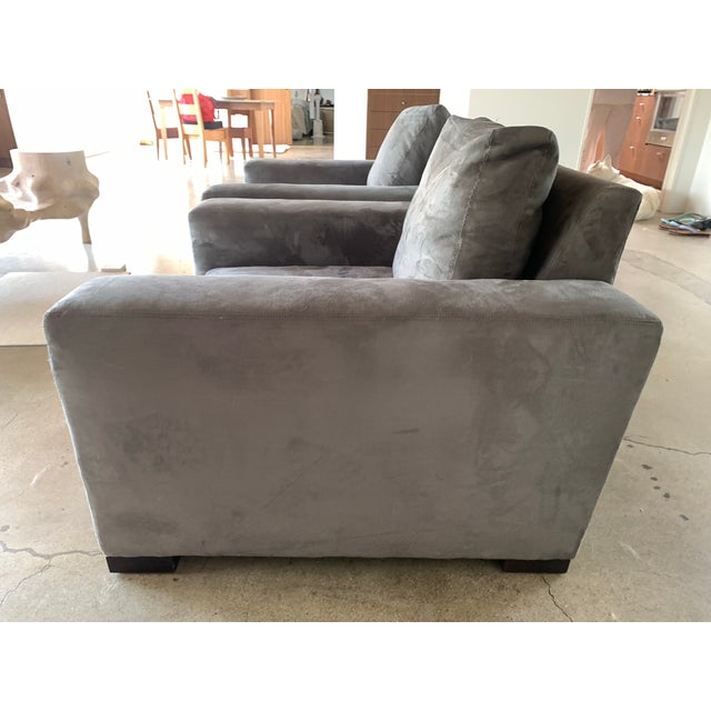 Pair of ultrasuede.club chairs with loose seat and back cushion and dark walnut stained wood feet.