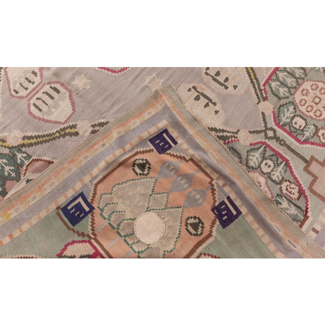 This antique Bessarabian kilim rug, handwoven circa 1920, features a striking symmetrical design characterized by a large...