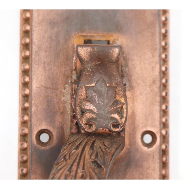 Antique door pull made of copper finish cast iron with an ornate Victorian design and a lock insert. The original mounting...
