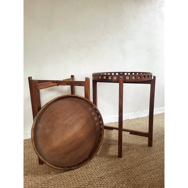 Round wooden side tables with removable tops with openwork edges.