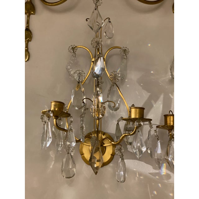 A pair of 1910 French gilt bronze lyre shape sconces with crystal hangings