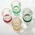 Clear shot glasses with colored bands of rubber. 1 - red, 1 - yellow, 1 - light green, and 1 - dark green.