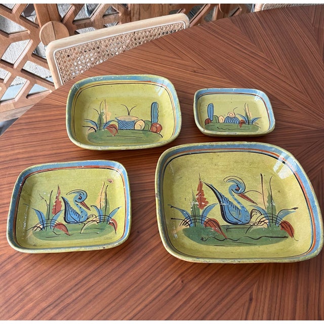A set of 4 beautifully hand-painted rustic nesting bowls crafted in 1940s Tlaquepaque, Mexico. Measurements: 12x10.5x2...