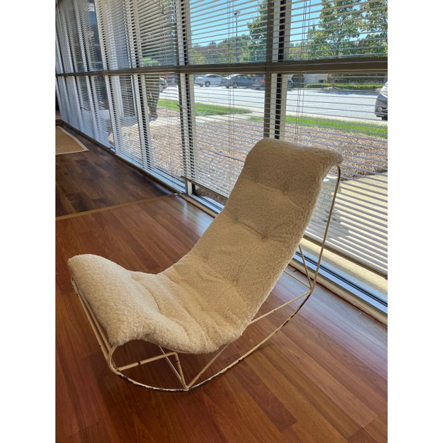 Reupholstered rocking chair in a beautiful off-white boucle fabric. The frame is a white metal, but shows signs of wear...