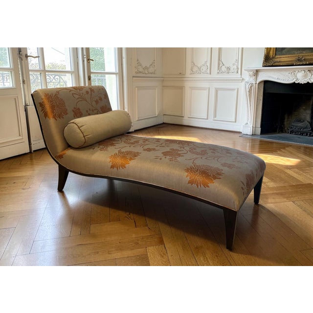 A lovely chaise or recamier with a dark wood frame, upholstered in damask embroidered silk fabric in hues of eggplant,...