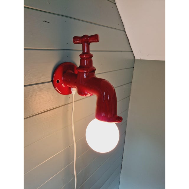 Vintage red ceramic wall light, in the shape of a faucet, produced by the German manufacturer Steinebach Leuchten in the...