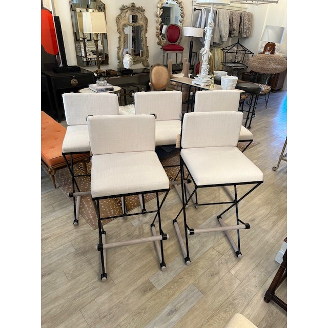 This is a Thomas Hayes Studio Pepe barstool. These have an iron frame with wood footrest and a linen like upholstery....