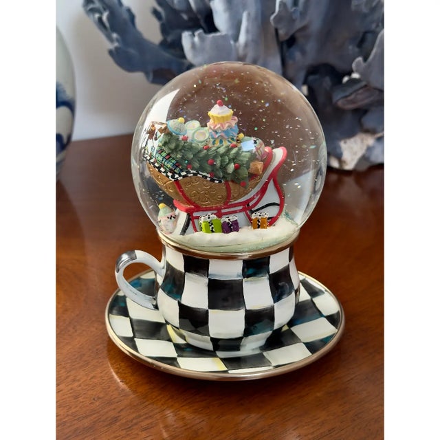 This is a vintage Mackenzie-Childs Christmas Holiday Snow Globe, it depicts a sleigh with presents and sits upon a courtly...