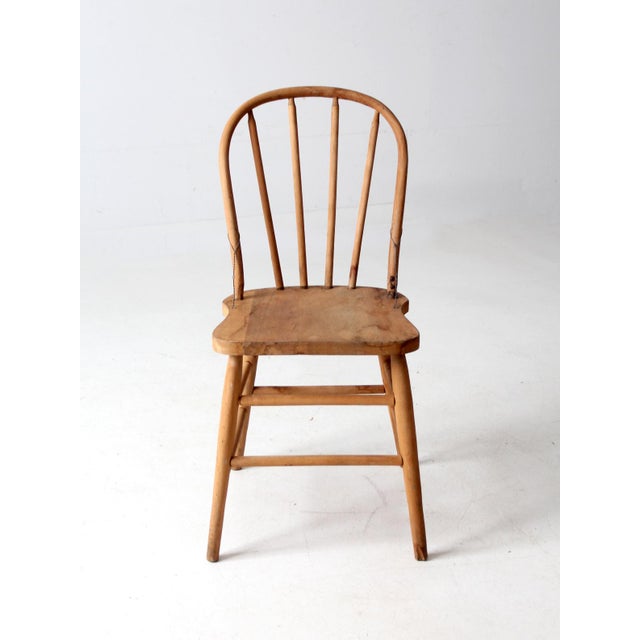 This antique Windsor chair features a graceful arched back and beautifully aged natural wood. The warm, unfinished surface...