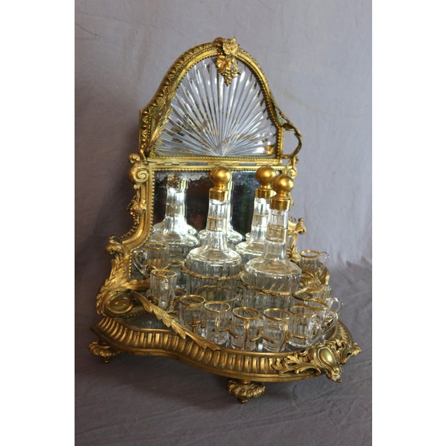 A gilt bronze and cut crystal pagoda-shaped liquor cabinet with a polylobed base. It rests on four toupie feet adorned...
