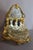 A gilt bronze and cut crystal pagoda-shaped liquor cabinet with a polylobed base. It rests on four toupie feet adorned...