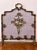 French Louis XVI style brass fireplace screen with an aged patina finish. A sculptural, polished brass frame features...