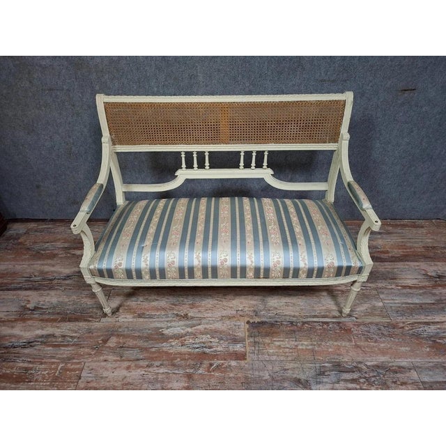 A very pretty louis xvi style sofa/bench, elegant and full of charm. its painted wooden frame rests on slender, tapered...