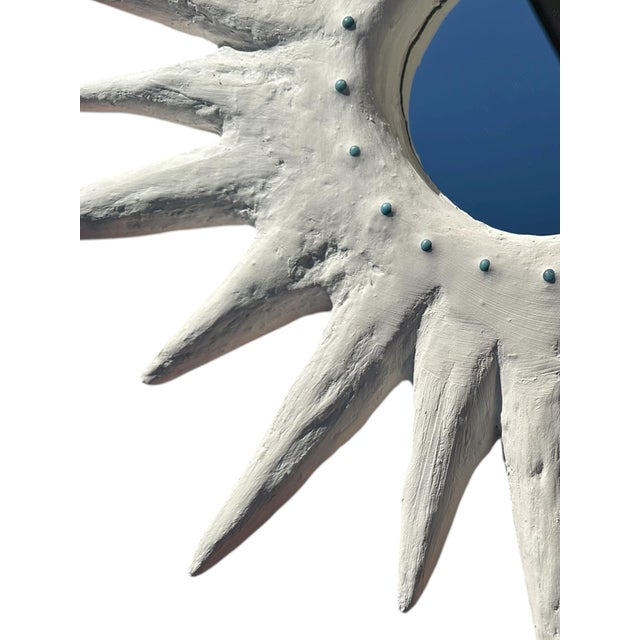 A sculptural plaster starburst mirror that radiates personality and texture. This style is embellished with turquoise...