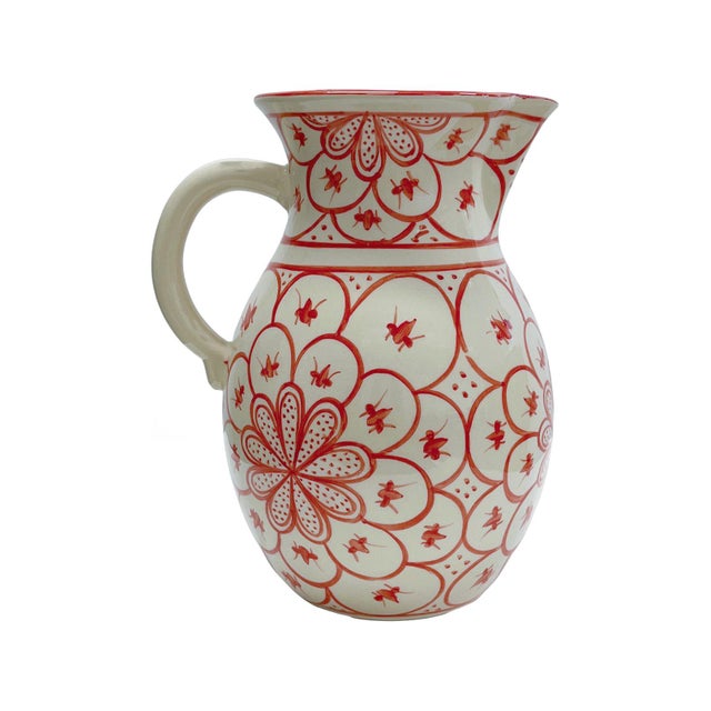 This handcrafted ceramic vessel features a vibrant red floral motif inspired by Mediterranean artistry. The intricate...