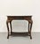 An elegant vintage writing desk showcasing finely woven rattan craftsmanship with a warm, richly patinated finish. The...