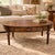 This vintage oval coffee table combines rich wood grain, useful concealed storage, and elegant traditional detailing....