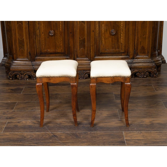 A pair of Italian walnut stools from the 19th century, with cabriole legs and new upholstery. Created in Italy during the...