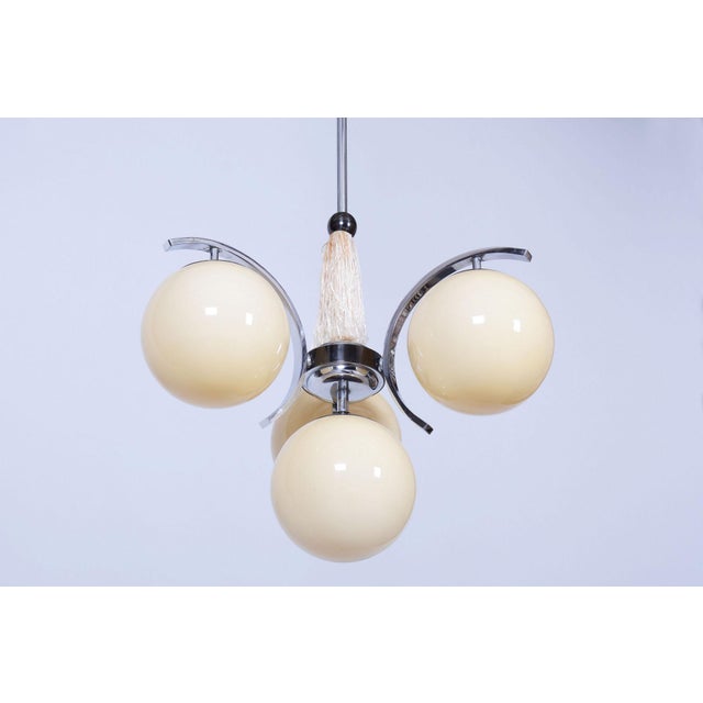 This four-light chandelier is an exclusive example of early 20th-century Czechoslovak design, harmoniously blending the...