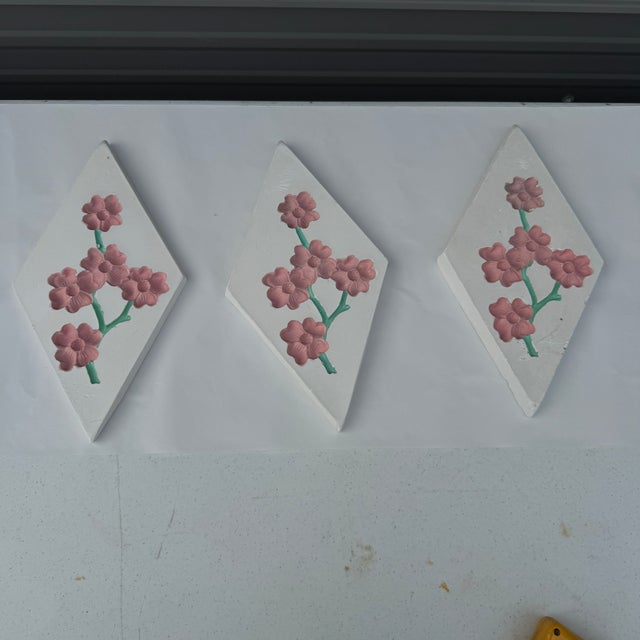Set of three Chalkware wall plaques of cherry blossoms on a white background. Circa 1950s perhaps earlier. They have the...